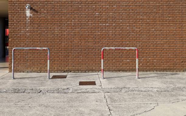 istock Grunge brick wall with concrete sidewalk and road, separated by a pedestrian barrier. 1268454212