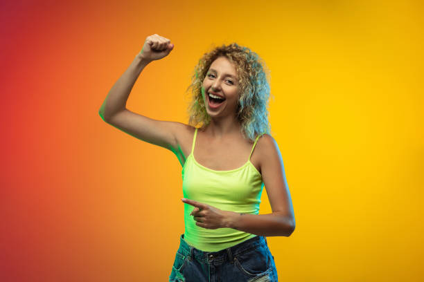 istock Caucasian young woman's portrait on gradient studio background in neon 1268454708