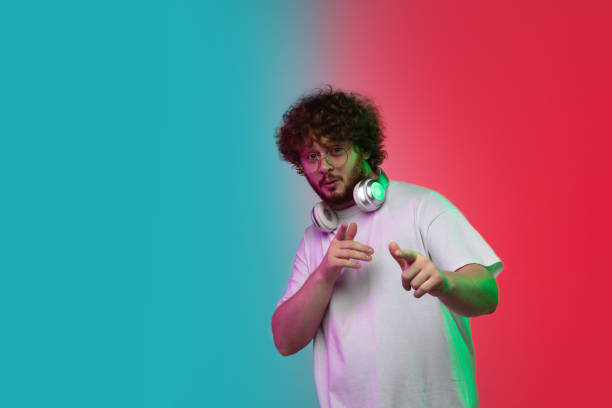 istock Caucasian young man's portrait on gradient studio background in neon 1268456011