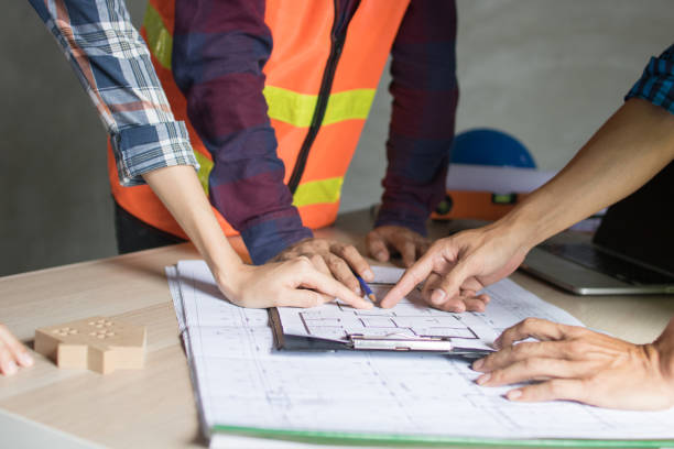 istock Architect working in office with blueprints,engineer thinking and planning inspection in workplace for architectural plan,sketching a construction project,Business construction concept. 1268459644