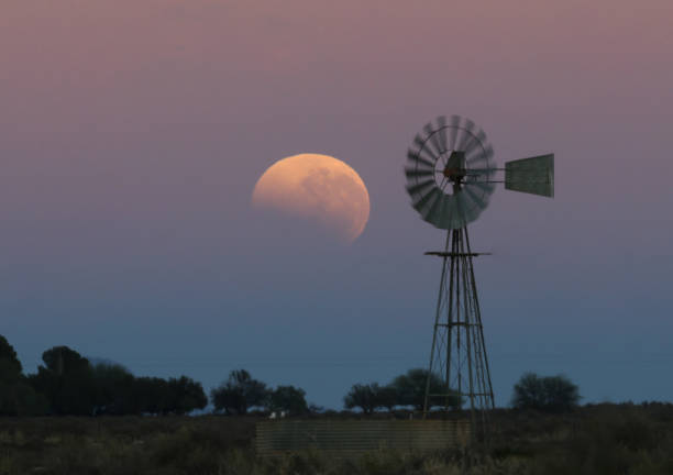 istock A blood moon sets behind a silhouette of a windpomp 1268463967