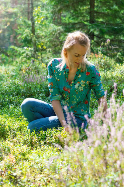 istock Blonde woman collecting cranberries in forest 1268464540