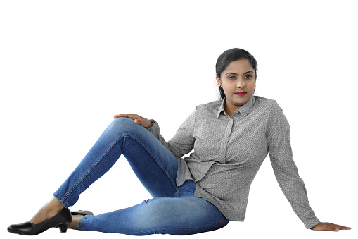 Cheerful young woman in casual wear posing against white background.