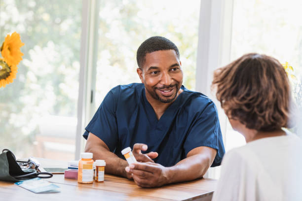 istock Sitting at dining room table, nurse explains medication to woman 1268467562
