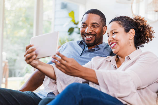 istock Mid adult couple uses digital tablet for selfie 1268467592