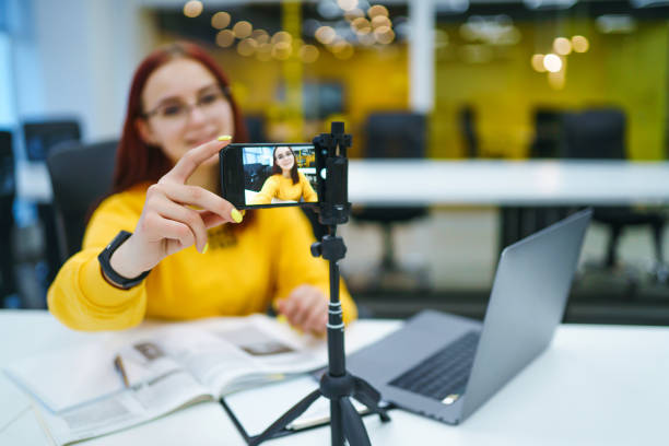 istock Hand woman holding camera for recording video while sitting at office. 1268470823