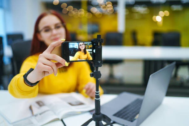 istock Hand woman holding camera for recording video while sitting at office. 1268470843