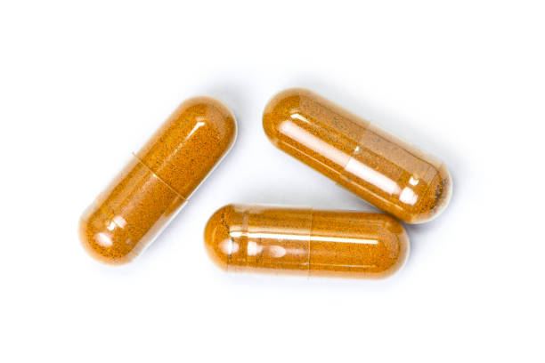 istock Turmeric powder capsules white background 1268471540