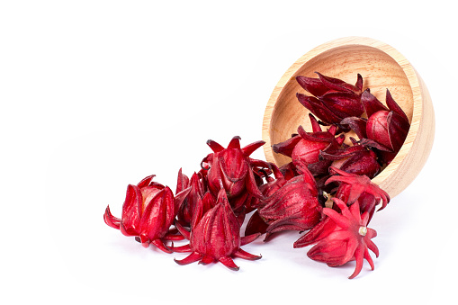 Fresh red Roselle fruit ( Jamaica sorrel, Rozelle or hibiscus sabdariffa ) in wooden bowl isolated on white background.