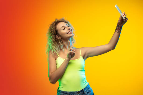 istock Caucasian young woman's portrait on gradient studio background in neon 1268472672