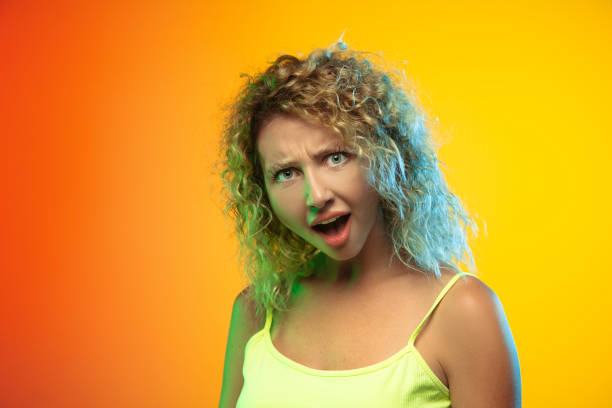 istock Caucasian young woman's portrait on gradient studio background in neon 1268472725