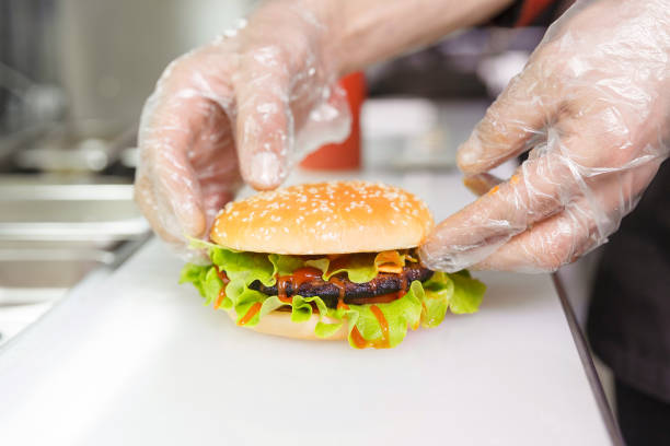 The chef's hands demonstrate the finished Burger.