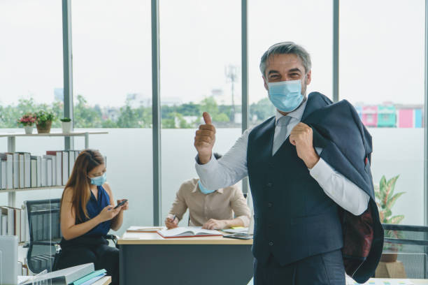istock Business people wearing masks working together in office 1268475772