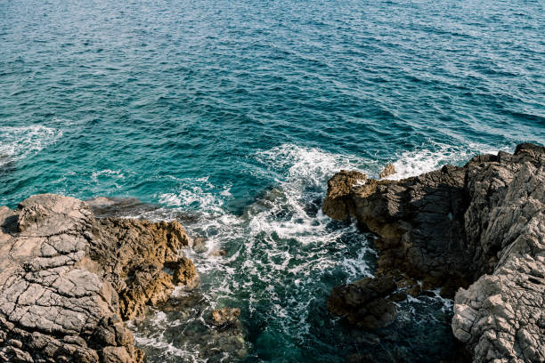 istock Rocks in the sea, waves hitting rocks. 1268475793
