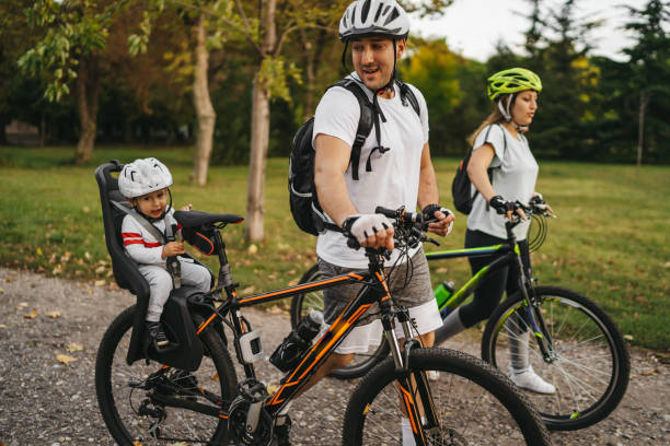 istock Happy young family with bicycles in park 1268477888