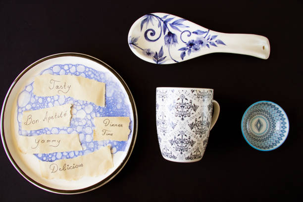istock Tasty, delicious, dinner time letters and text, empty blue tableware, bowl and plate on the blue table. Dish set. Table setting. 1268479185