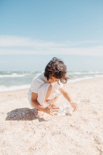istock Curly young toddler girl with sea shell 1268479502