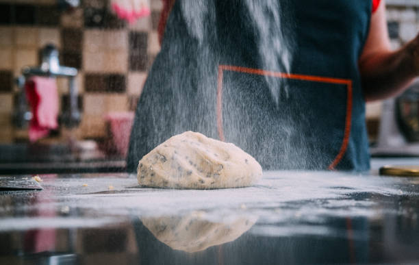 istock Chef hands pouring flour powder on raw dough 1268484706