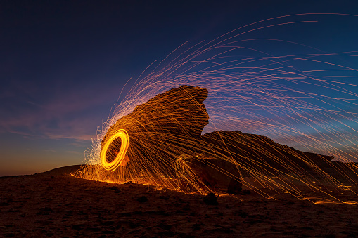 A steel wool on fire at night (night photography using a slow shutter speed) - selective focused on the subject.