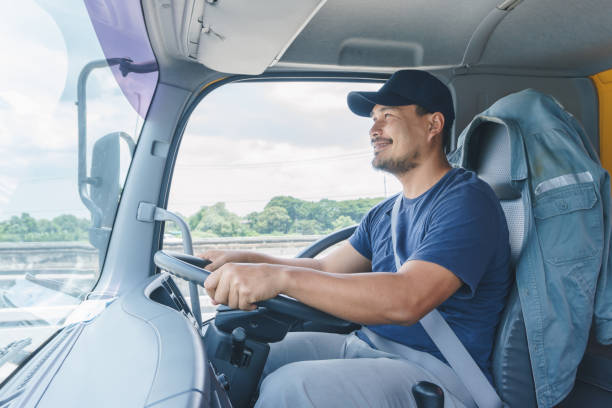 young man driving a car Smile Confidence Young Man Professional Truck Driver In Business Long transport transporter stock pictures, royalty-free photos & images