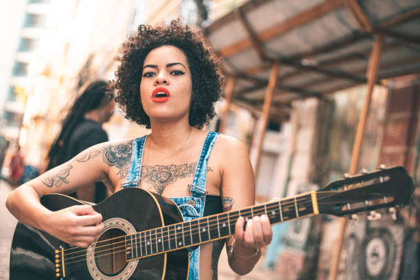 уличный музыкант, играющий на акустической гитаре - 20s acoustic guitar adult attractive female стоковые фото и изображения