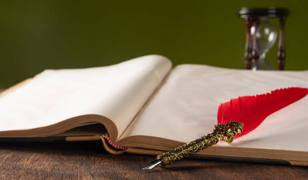 istock Fountain pen with red feather on a notebook and 