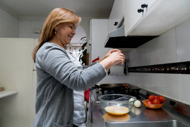 istock Woman looking happy making breakfast at home 1268490123