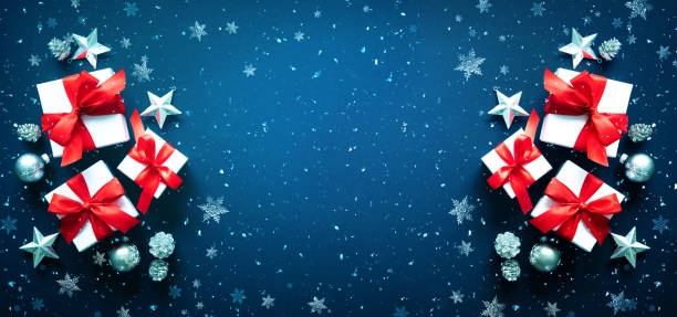 istock Christmas gift boxes and snowflakes on blue background 1268490403