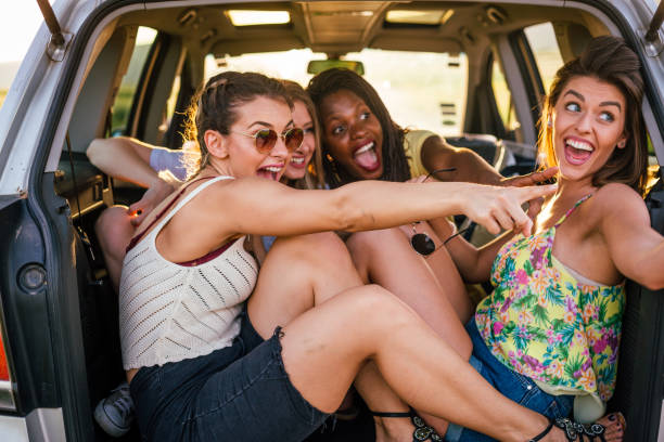 istock Girls having fun in a trunk of the car 1268494607