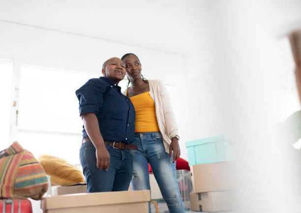 istock Portrait lesbian couple standing in new home surrounded by boxes 1268495280