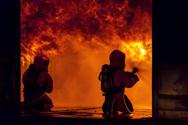 istock Firefighters use water fog spraying down fire flame in building. 1268499559