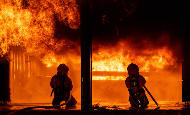 istock Firefighters use water fog spraying down fire flame in building. 1268499641