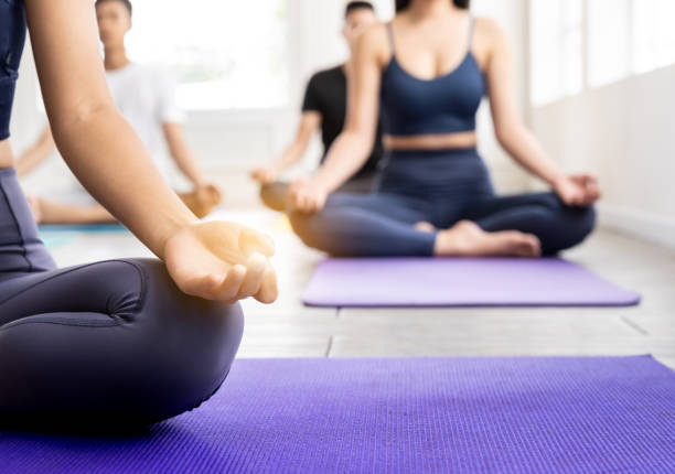 Close up Asian sporty people practicing yoga in Class Lotus position stock photo