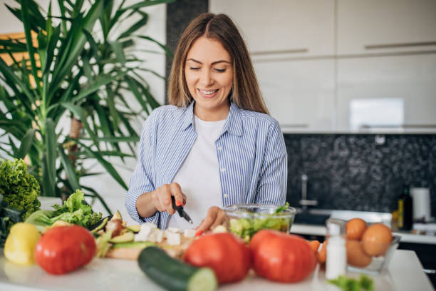 istock Woman in kitchen preparing a vegan salad 1268501752
