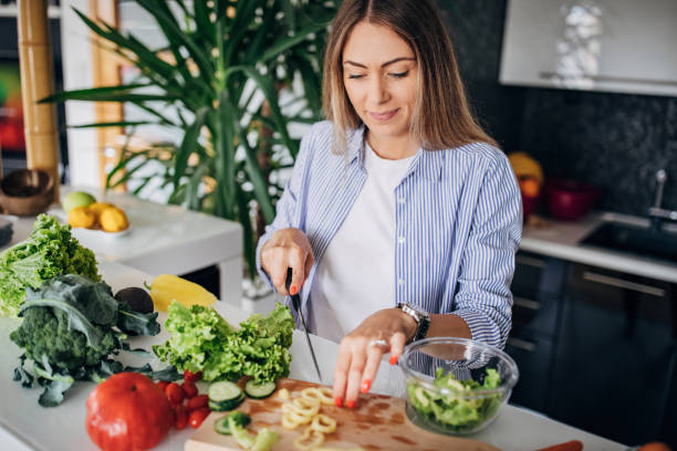 istock Woman in kitchen preparing a vegan salad 1268501818