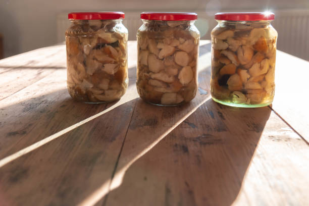 istock Canned mushrooms boletus in three glass jars on wood rustic table 1268502069