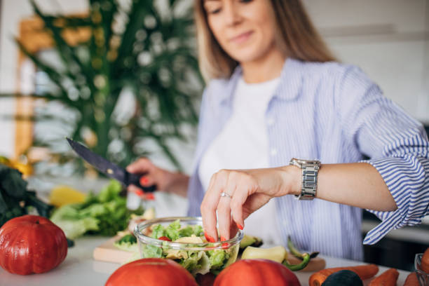 istock Woman in kitchen preparing a vegan salad 1268503043