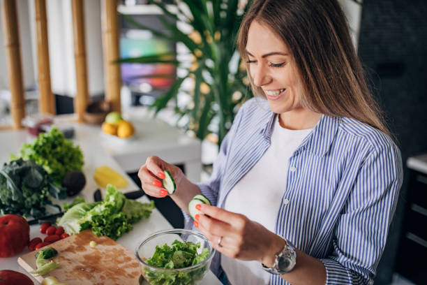 istock Young woman preparing a vegan salad in kitchen 1268503071