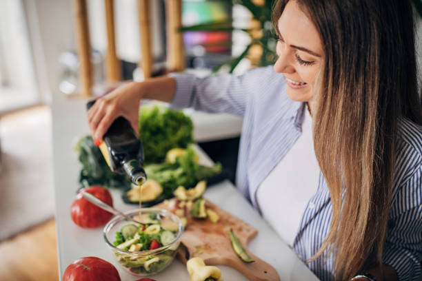 istock Young woman preparing a vegan salad in kitchen 1268503096