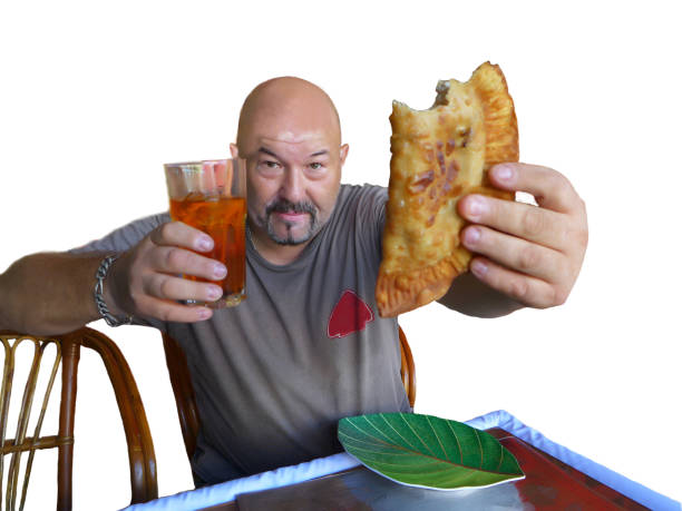 istock Smiling brutal man eating russian cheburek pie, isolated 1268503112