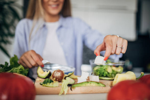 istock Young woman preparing a vegan salad in kitchen 1268503612