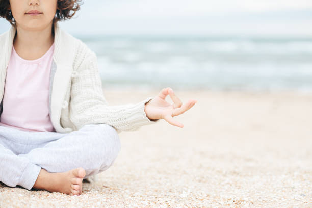 istock little girl meditating on the beach 1268505356