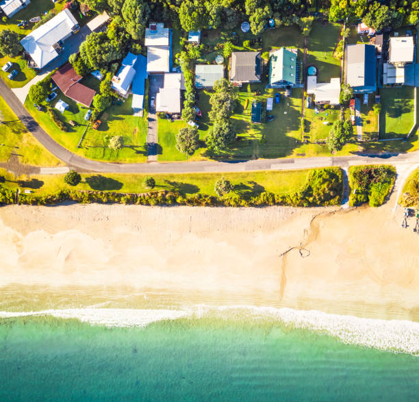 Beach houses from directly above An aerial view from directly above the beach at Opito Bay, an idyllic holiday spot on the Coromandel Peninsula in New Zealand. coromandel peninsula stock pictures, royalty-free photos & images
