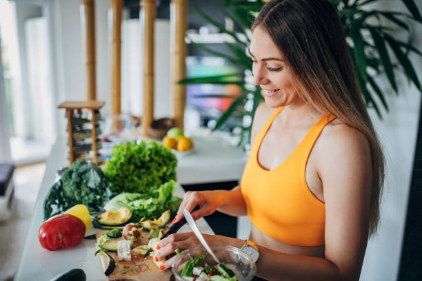 istock One fit woman making healthy vegetable salad for breakfast 1268505584