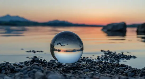A lensball on little stones at the water of a lake in Bavaria, Germany