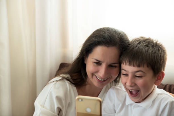 istock Mother with boy using smartphone for chat with friends or snapping selfie. Education technology. Soft focus 1268510112