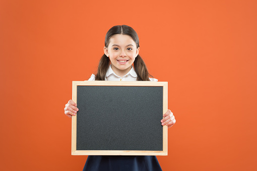 banner concept. blackboard for copy space. information. write hometask. back to school. happy teachers day. 1 september. small girl demonstrate announcement. happy small school girl with chalkboard.