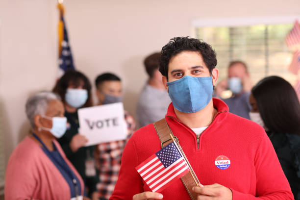 istock Latin descent man votes in USA election wearing mask. 1268512898