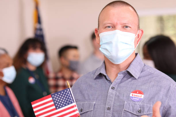 istock Man votes in USA election wearing mask. 1268513288