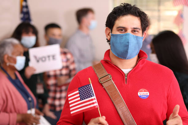 istock Latin descent man votes in USA election wearing mask. 1268513530